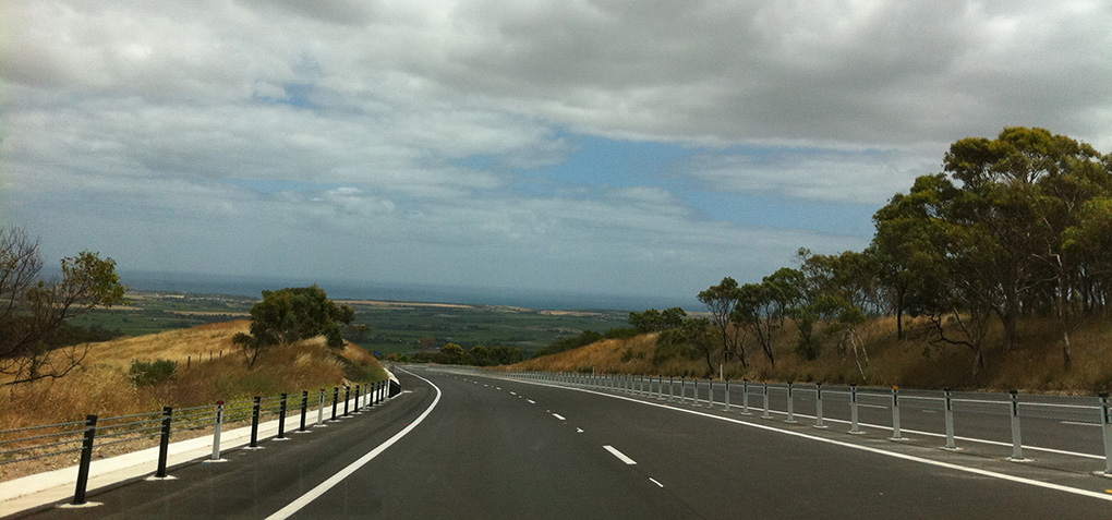 A wire rope barrier to along the left edge of Dukes Highway.