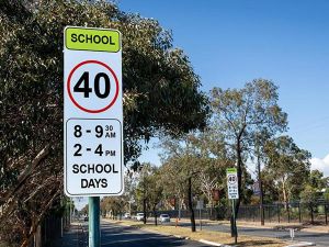 Two signs on both sides of the road indicating the 40 km/h school speed limit near schools.